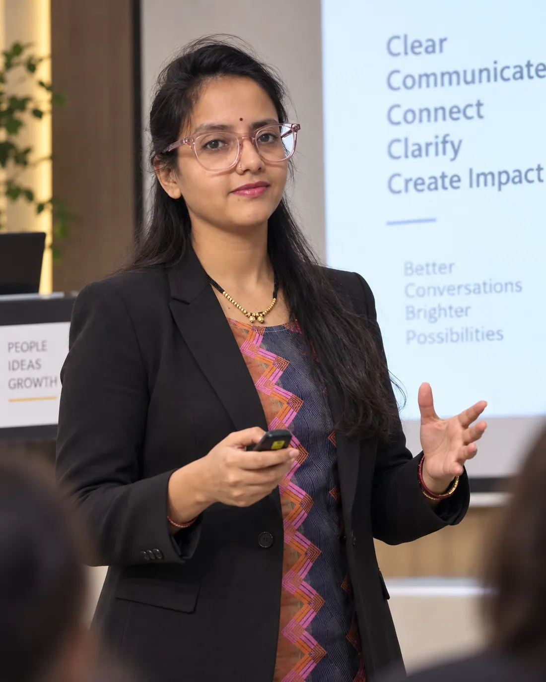 Sapna presenting a clearer communication approach beside a screen